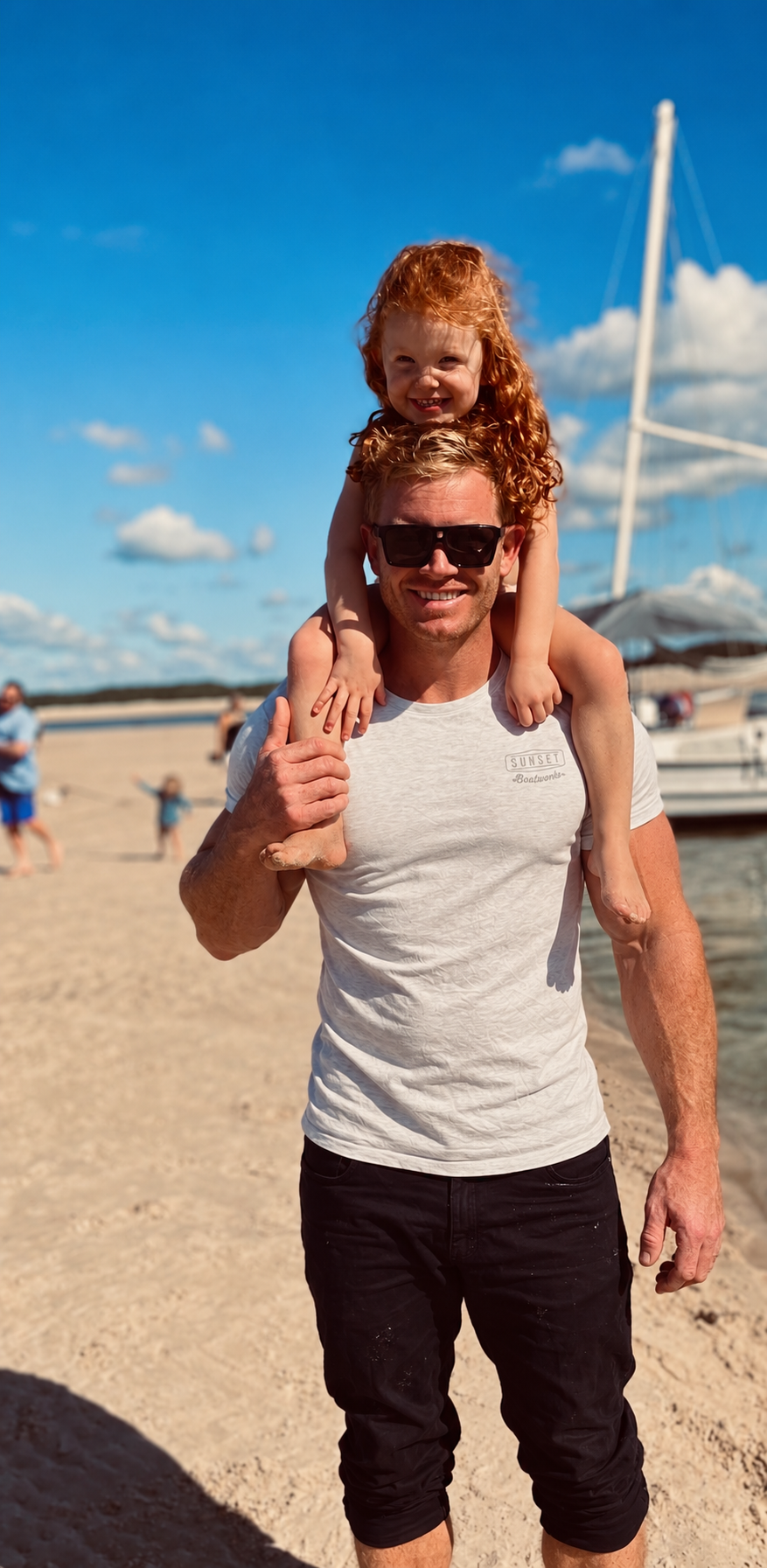 Daniel Lawley with his daughter Brooke on his shoulders by the water